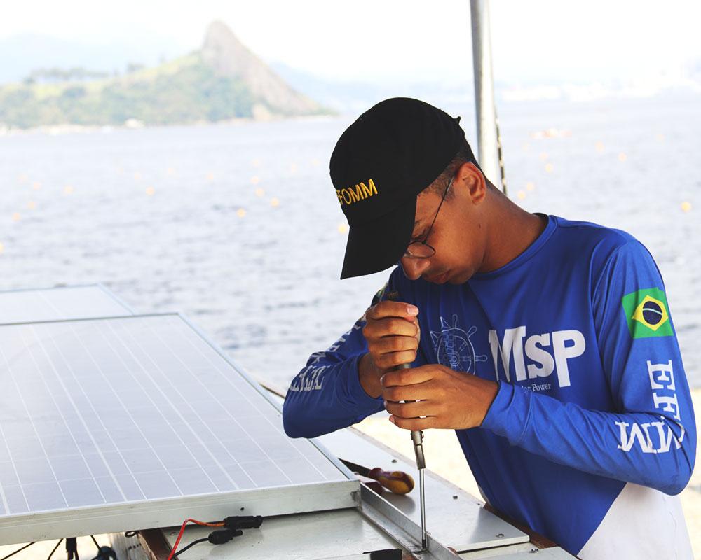 foto 2 aluno da efomm fazendo ajustes no barco solar