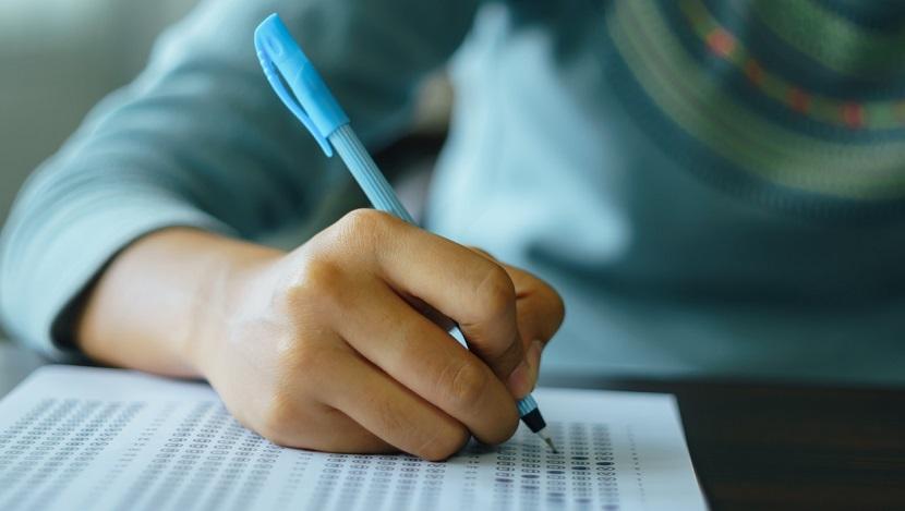 College student write on exam paper