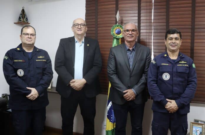 Autoridades brasileiras em reunião formal com bandeira.