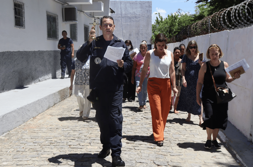 Grupo de pessoas caminhando em rua de paralelepípedo.