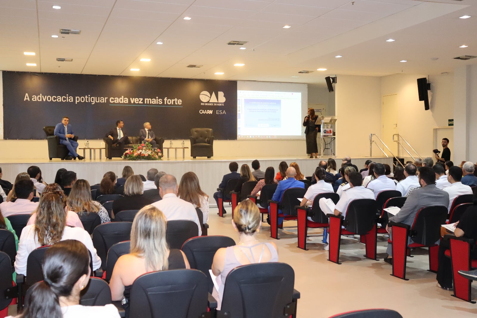 Palestra da OAB em auditório cheio.