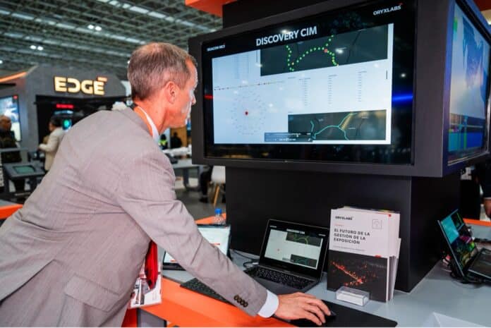 Homem interagindo com tecnologia em exposição de segurança.