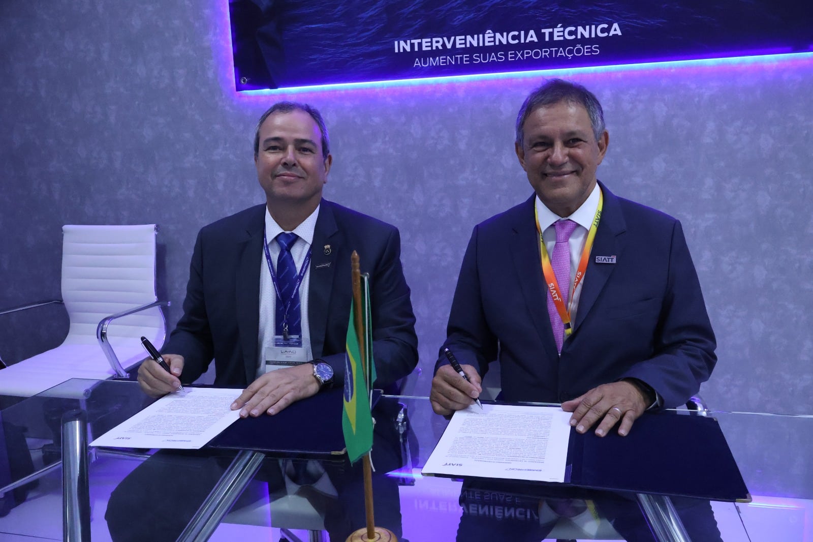 Homens assinando documentos em evento de exportação