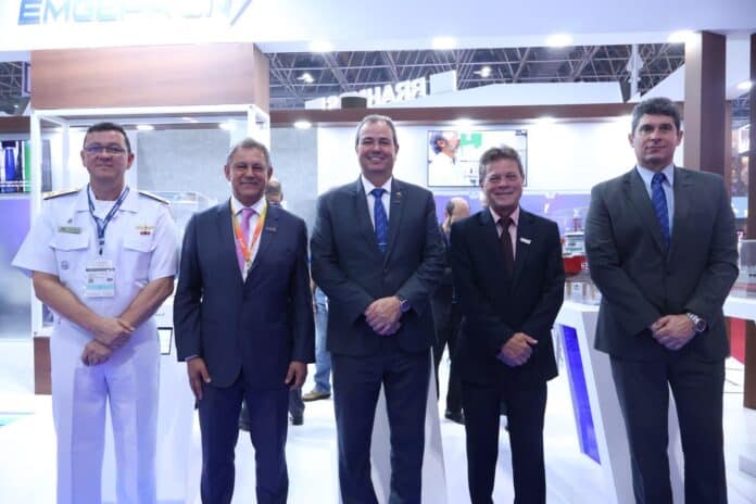 Cinco homens em trajes formais em evento empresarial.