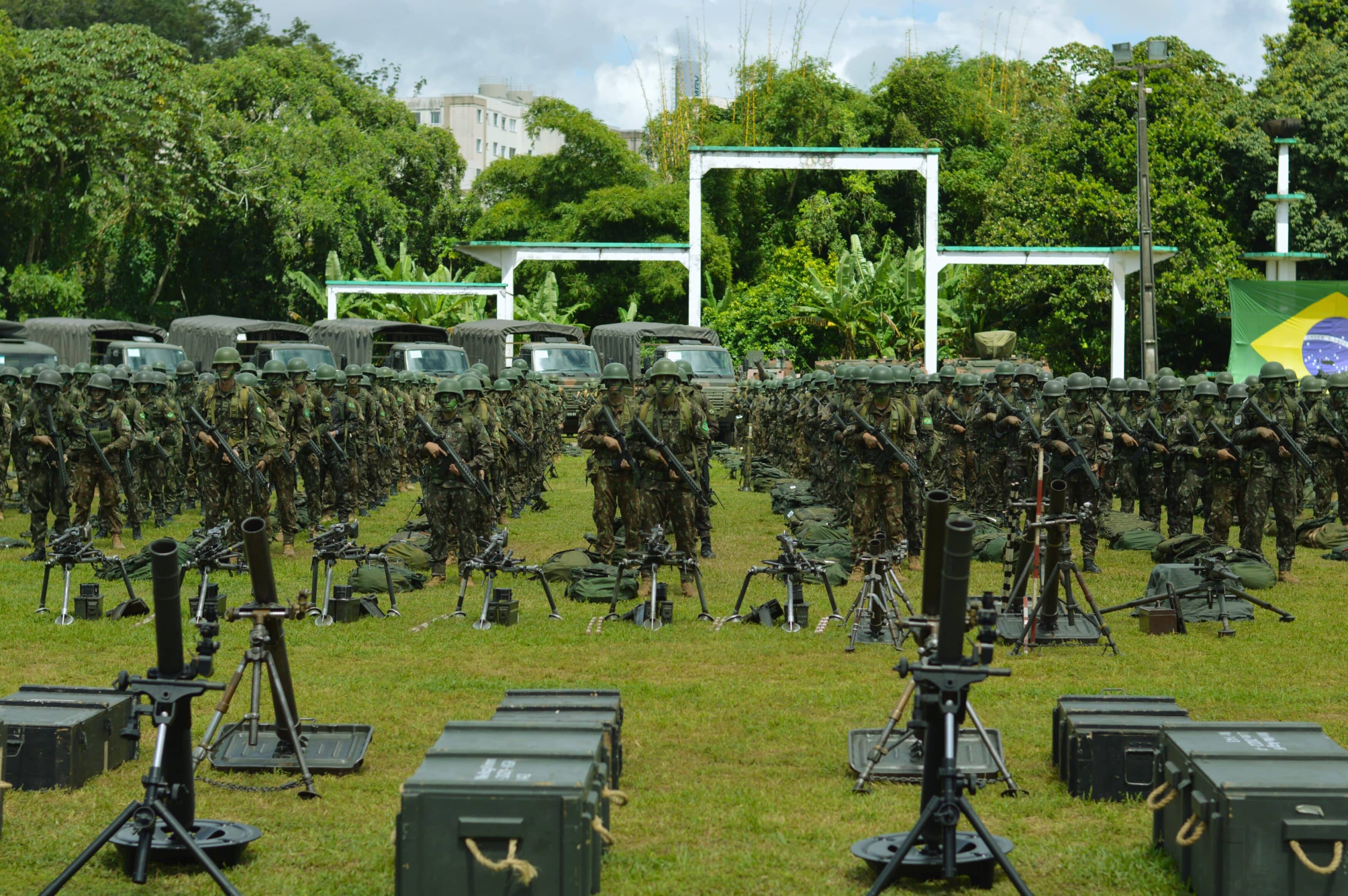 Soldados em formação com equipamentos militares.