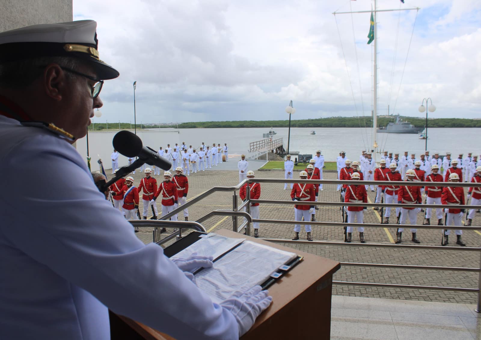 Oficial militar discursa em cerimônia naval.