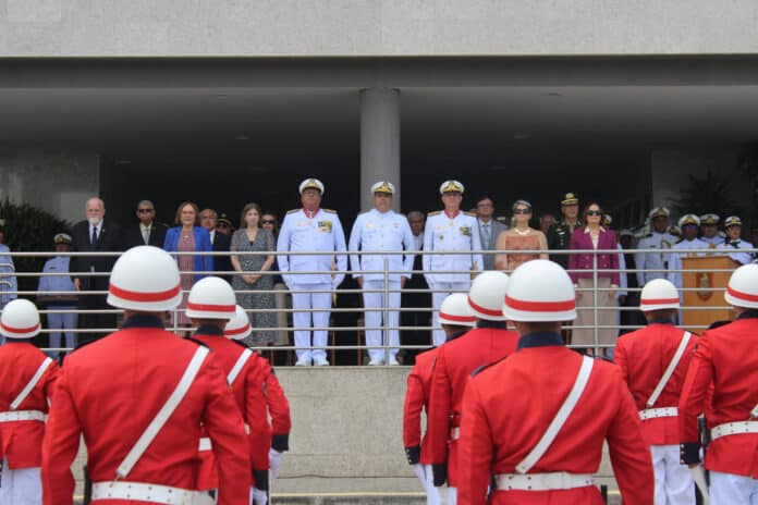 Cerimônia militar com oficiais e soldados uniformizados.