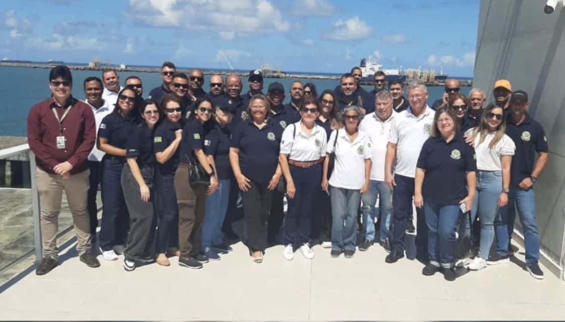 Grupo de pessoas em encontro à beira-mar.