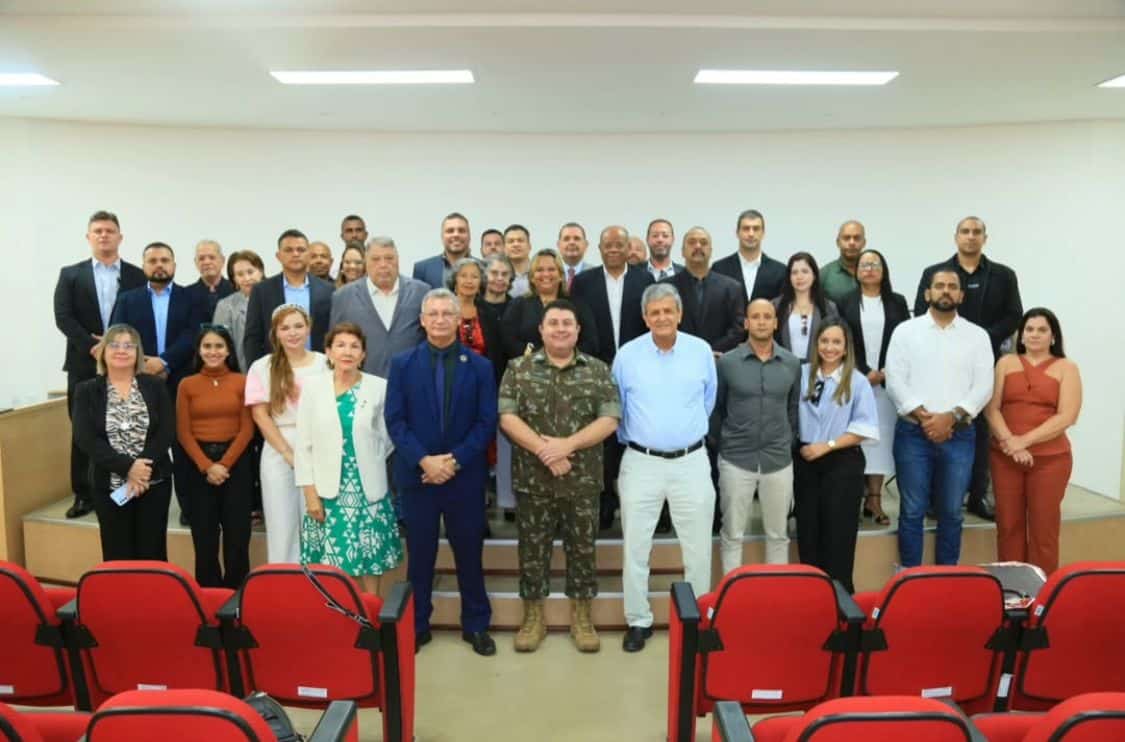 Grupo de pessoas em auditório com cadeiras vermelhas.