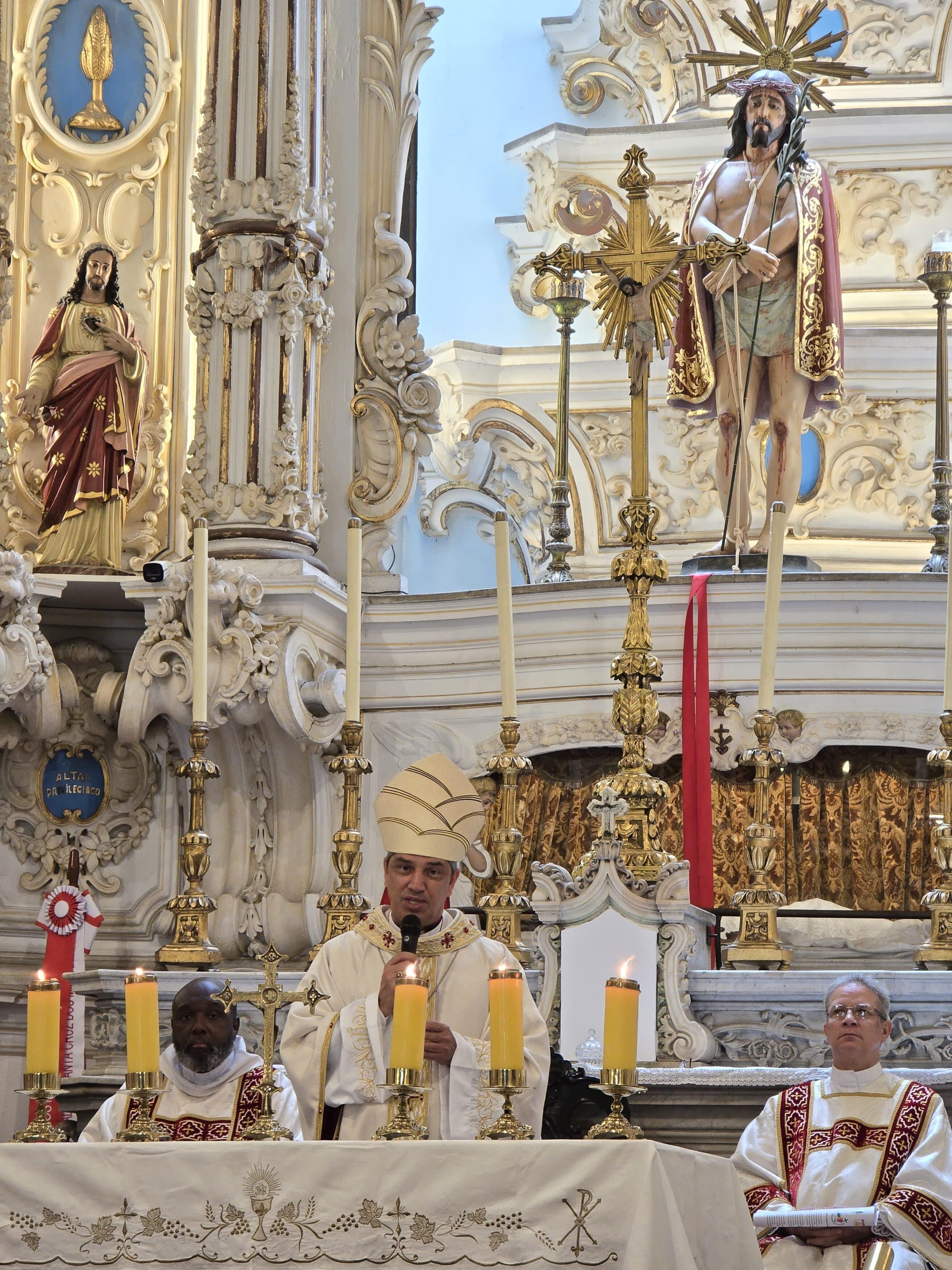 Missa em altar barroco com imagens religiosas.