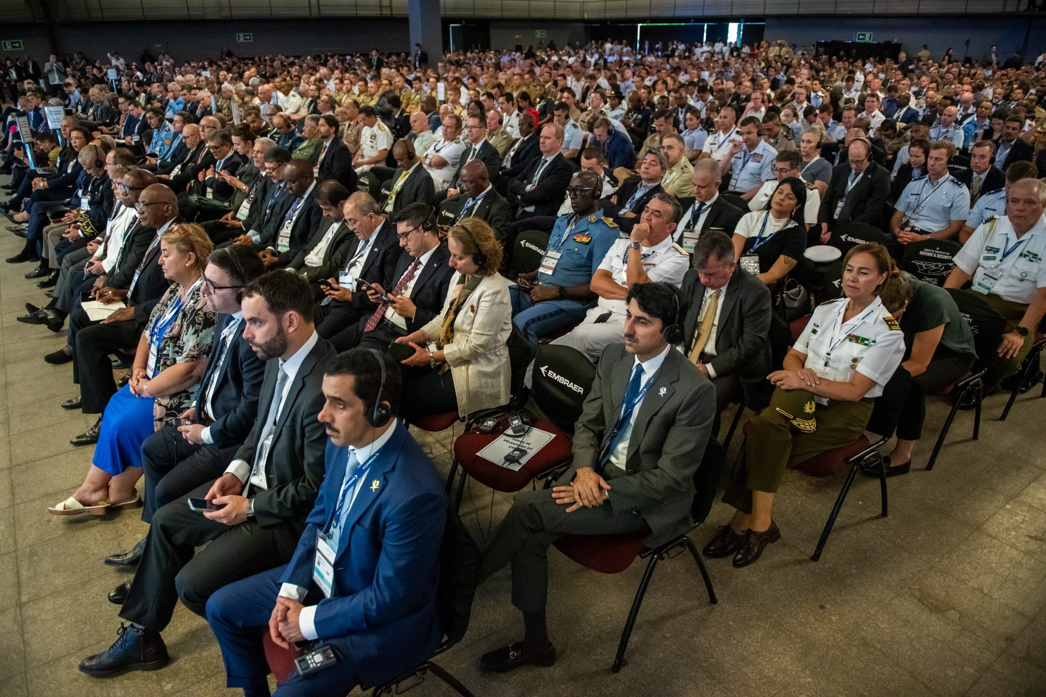 Pessoas assistem conferência em auditório lotado.