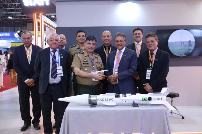 Homens posando com míssil em evento de defesa.