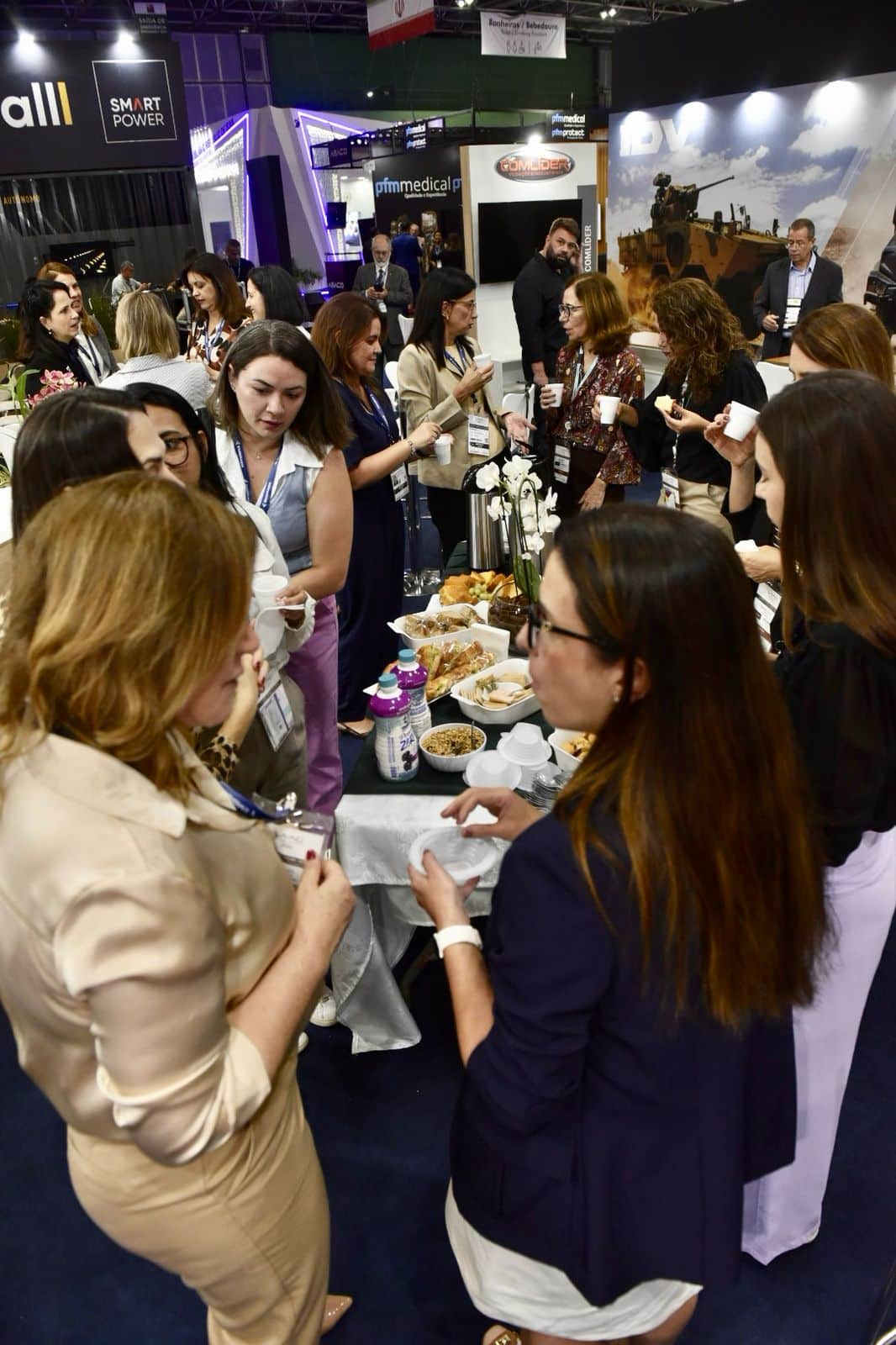 Pessoas conversando em evento empresarial com buffet.