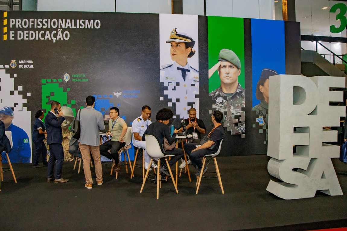 Stand militar com militares reunidos em exposição.