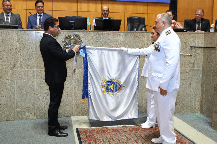 Cerimônia oficial com bandeira e autoridades.