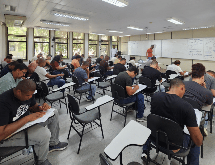 Estudantes fazendo prova em sala de aula.
