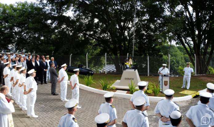 Cerimônia com militares em fardas brancas ao ar livre.