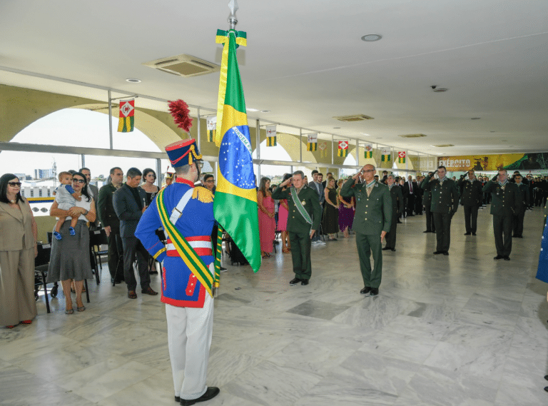 Cerimônia militar com bandeira do Brasil sendo saudada.