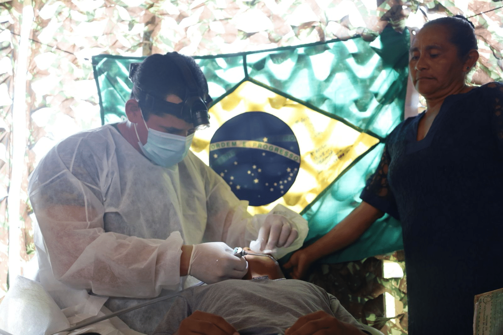 Dentista atende paciente em clínica improvisada no Brasil.