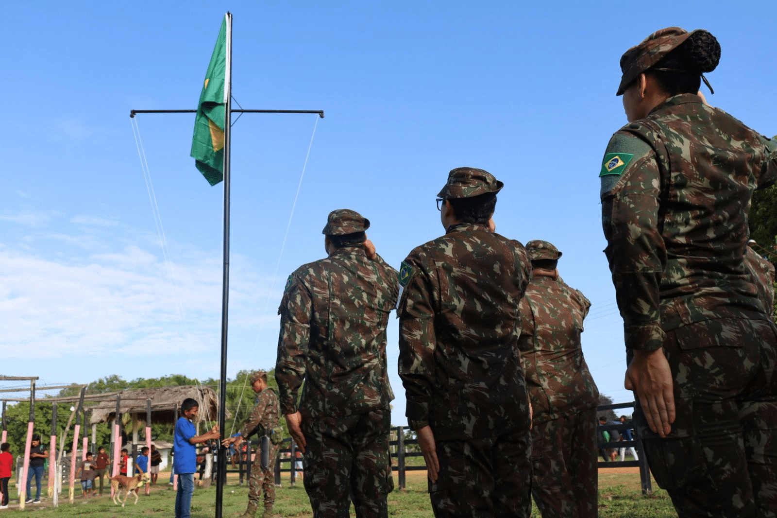 Soldados brasileiros prestam continência à bandeira nacional.