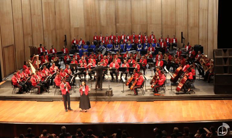 Orquestra sinfônica em apresentação no palco.