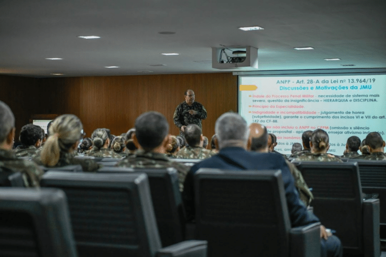 Militares assistem palestra em auditório sobre lei militar.