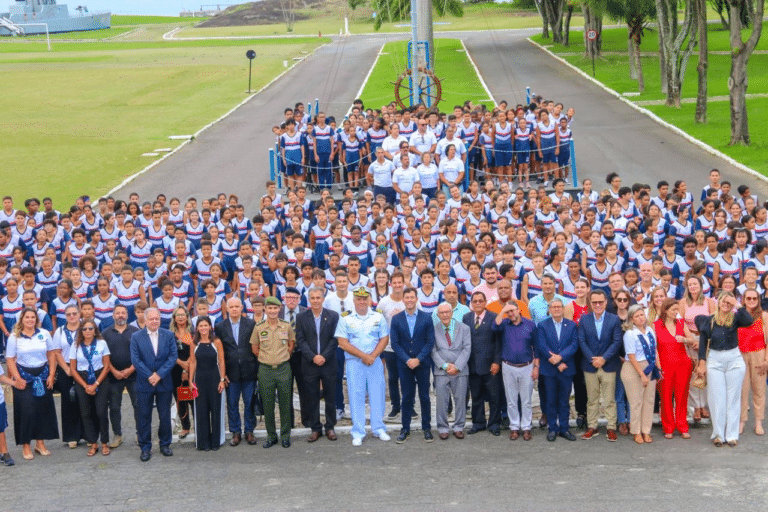 Grupo de estudantes e adultos em cerimônia.