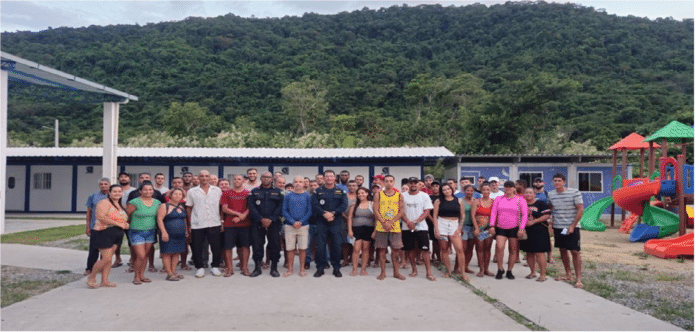 Grupo de pessoas reunidas em frente a escola.
