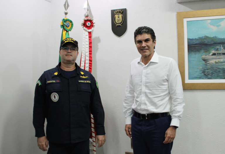 Dois homens em escritório com bandeiras e pintura.