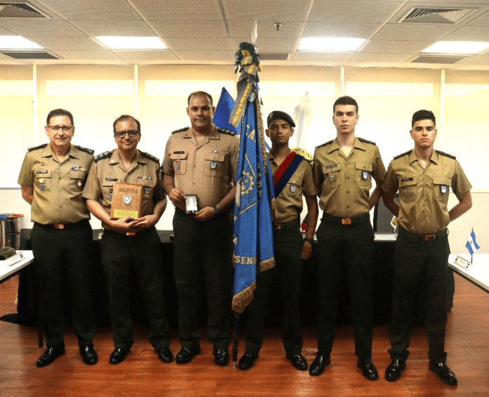 Oficiais do exército posam com bandeira em cerimônia.