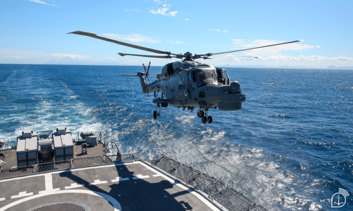 Helicóptero pousando em navio no mar