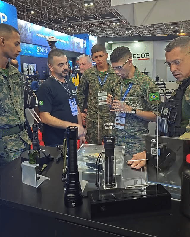 Militares observam equipamentos em exposição.
