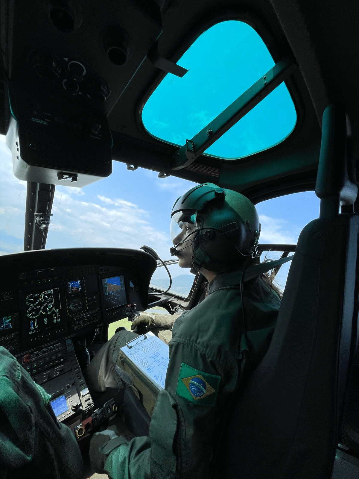 Piloto helicóptero com uniforme, cabine e painel de controle.