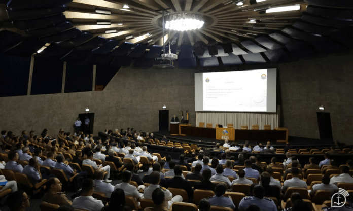 Auditório com palestra e público atento.