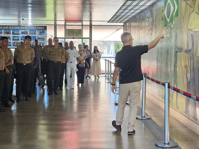 Grupo de militares em visita guiada a mural.