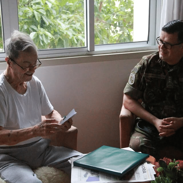 Visita de militar a idoso em casa.
