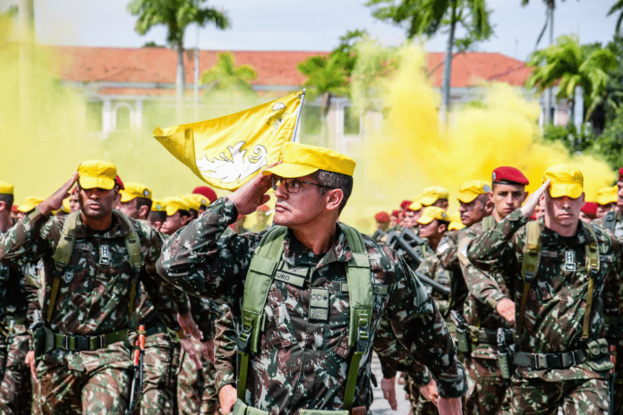 Soldados marcham com bandeira e fumaça amarela