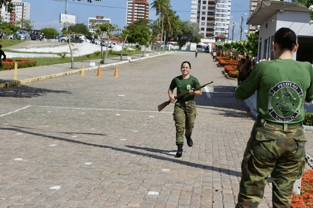 Treinamento militar ao ar livre com recrutas em corrida.