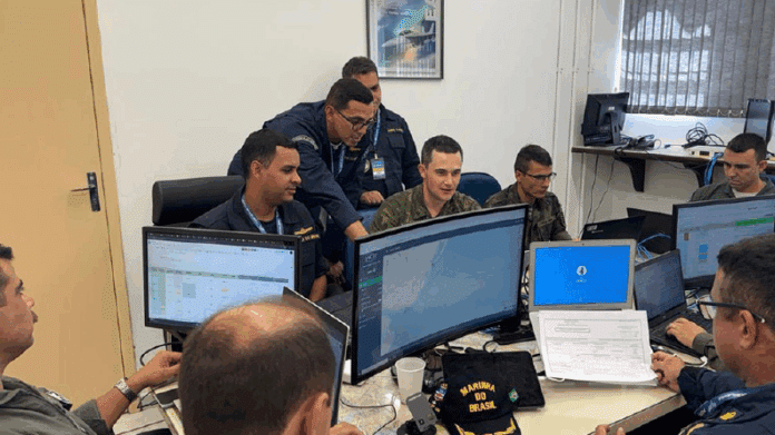 Militares trabalham em computadores em uma sala de controle.