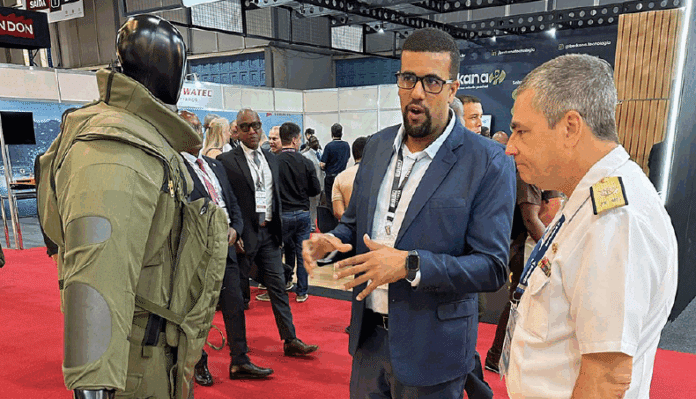 Pessoas conversando em exposição de tecnologia militar.