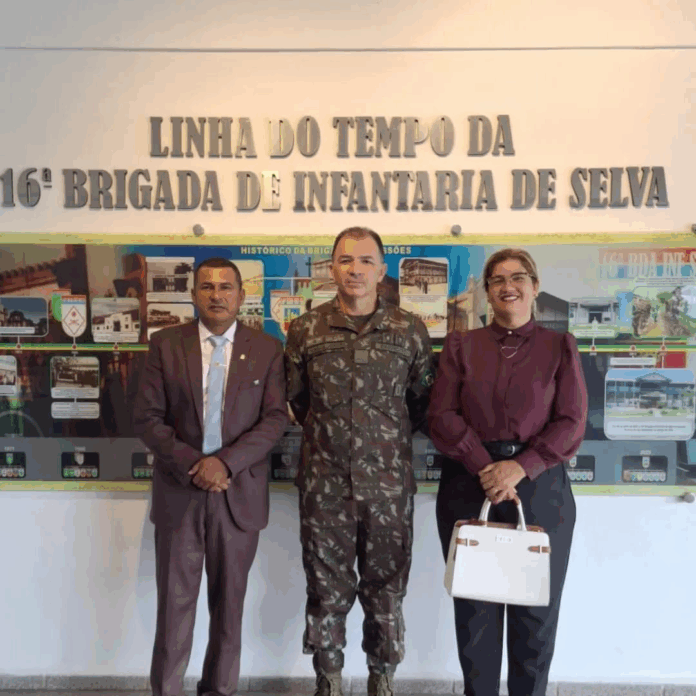 Três pessoas em frente à 16ª Brigada de Infantaria.
