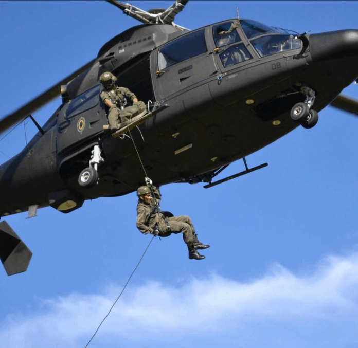 Soldado descendo de helicóptero durante operação militar.