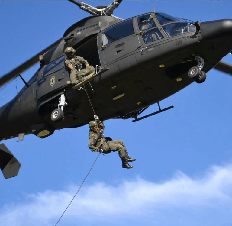 Soldado descendo de helicóptero durante operação militar.