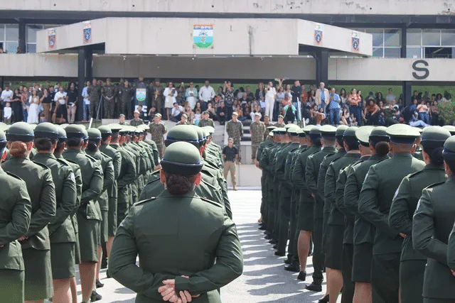 Formatura militar com público ao fundo.