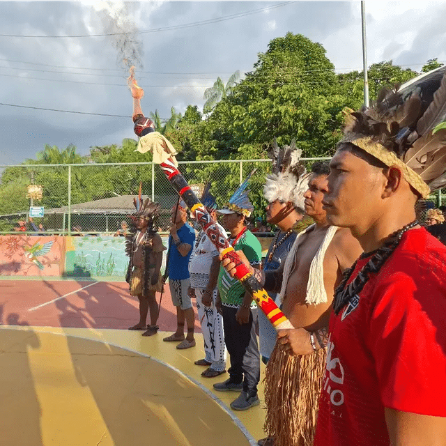 Indígenas participam de cerimônia tradicional ao ar livre.