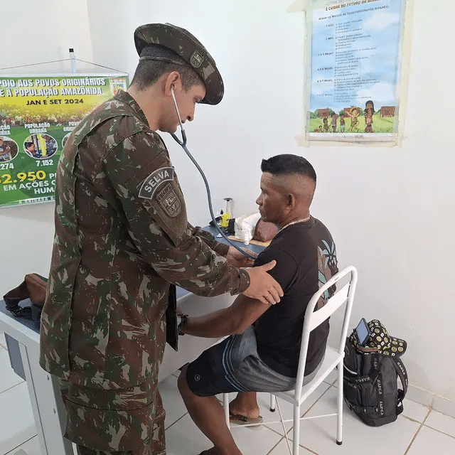 Militar examina paciente em posto de saúde remoto.
