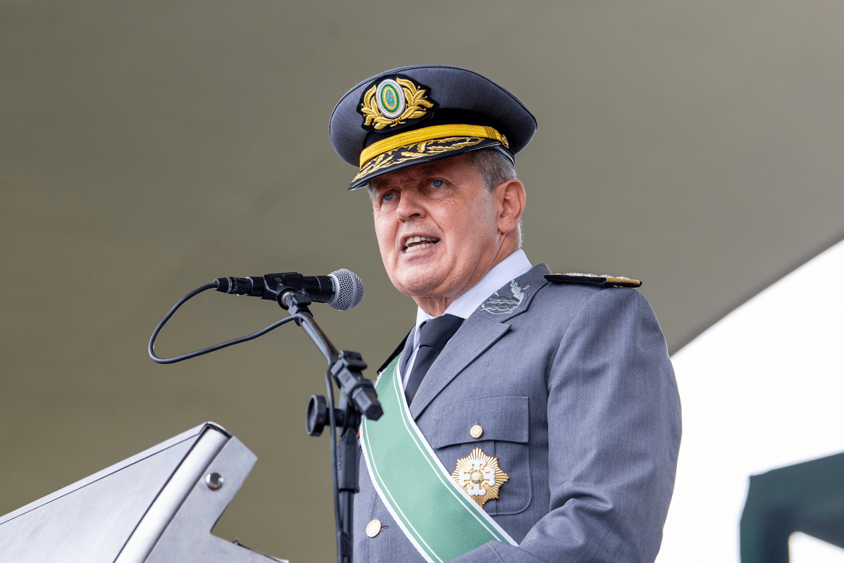 Oficial militar discursando em cerimônia com microfone.