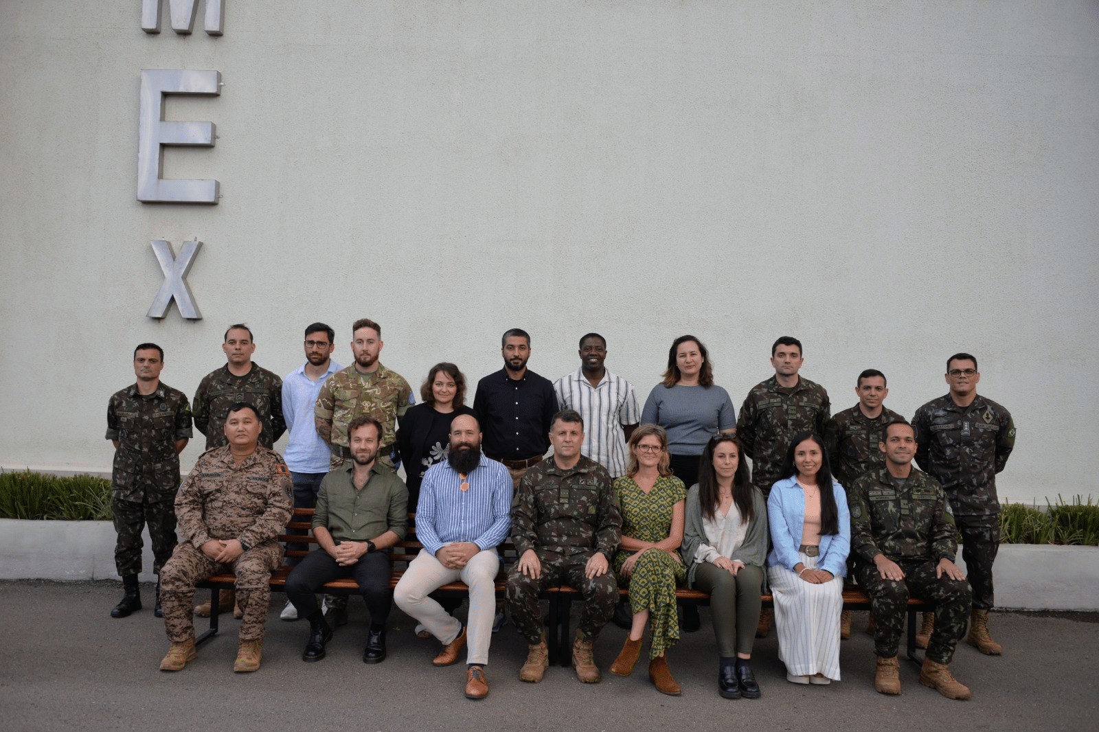 Grupo de militares e civis em frente ao prédio.