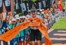 Atleta cruza linha de chegada em competição de triatlo.