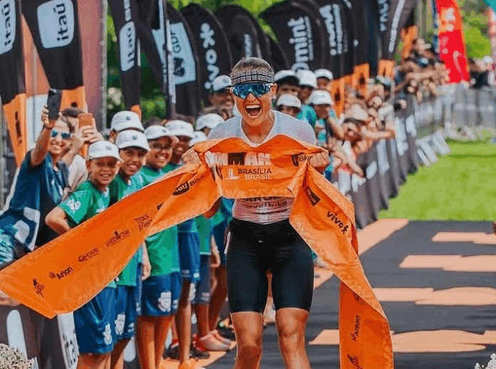Atleta cruza linha de chegada em competição de triatlo.
